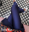 Navy blue leggings worn by a person on a patterned floor.