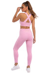 A woman modeling a light pink activewear set consisting of a sports bra and leggings, shown from the back against a plain white studio background.