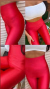 A four-panel collage showing a model wearing shiny red high-waisted leggings, paired with a white crop top in an outdoor setting.